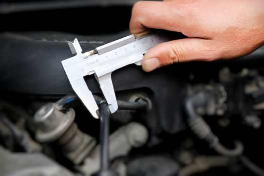 Worker measuring diameter in auto repair service