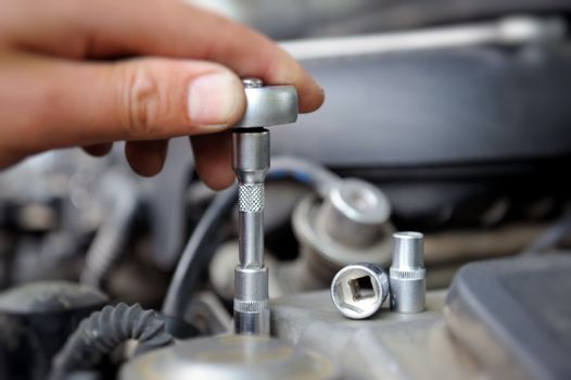 Hands of car mechanic in auto repair service