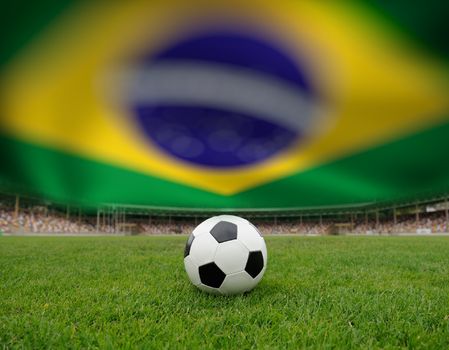 Soccer ball on the field of stadium on Brazil flag background