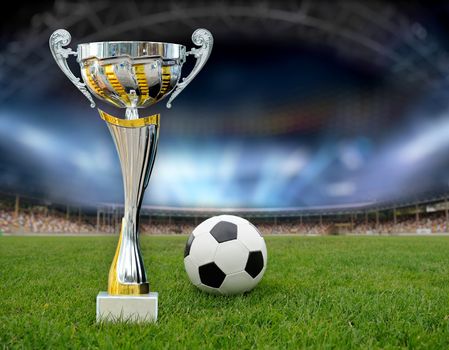 Golden trophy in grass on soccer field background