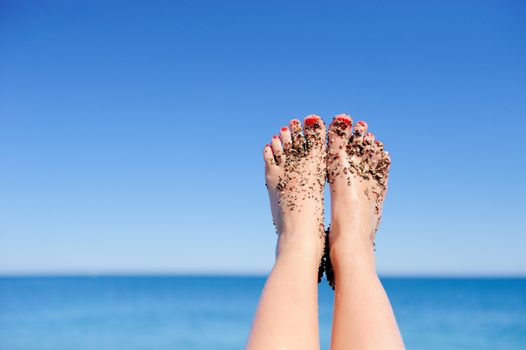 Vacation holidays. Woman feet closeup of girl relaxing on beach