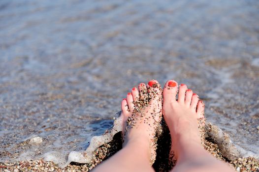 Vacation holidays. Woman feet closeup of girl relaxing on beach