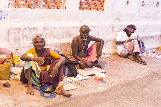Documentary editorial image. Pondicherry, Tamil Nadu, India - June 25 2014. Very poor man and woman sitting in the street asking for food. Poverty in the world