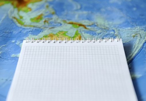 Notebook on a background map of the world. Traveling concept