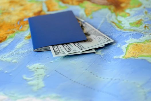 Passport and money on a background map of the world. Traveling concept