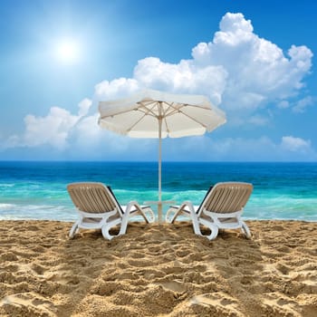 Beach chair and white umbrella on sand beach