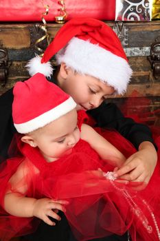 Christmas baby and her brother wearing a red hats