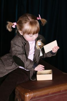 Little girl in vintage attire playing with a puzzle