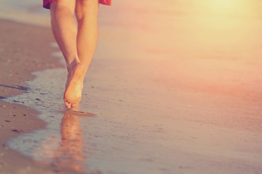 Running legs and shoes of runner jogging on beach