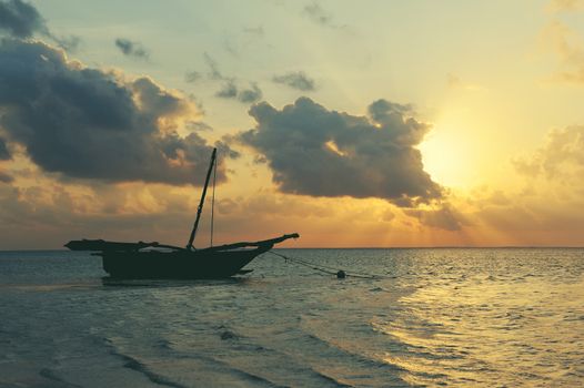 Beautiful tropical sunset with boat in ocean