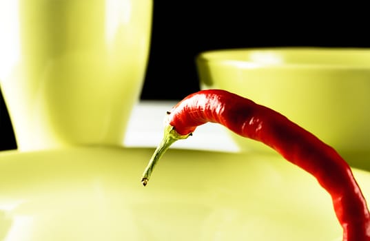  Red hot pepper on green dish over white wood. Horizontal image.