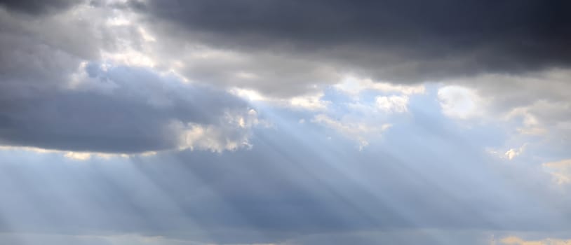 Light rays shine through the dark cloud. Rays of light shining in the morning