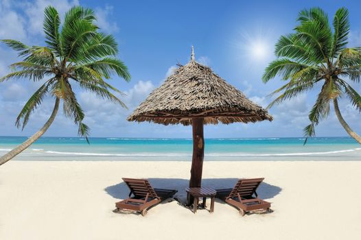 Beautiful tropical beach witn straw umbrella and palm. Straw umbrella and palm at the beach