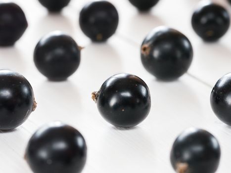 Fresh black currants on white wooden background. blackcurrants close up. Shallow DOF