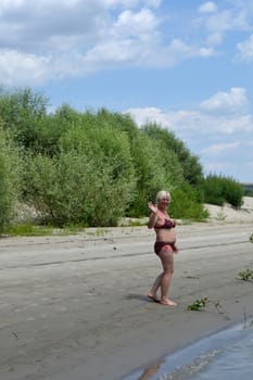 Woman on sunny beach on the island.
The sand is hot