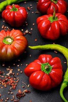 Red bell pepper, and spices on dark background