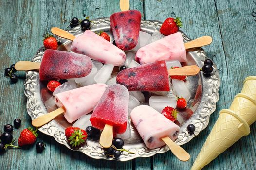 Ice-cream and summer berries in metal tray with ice