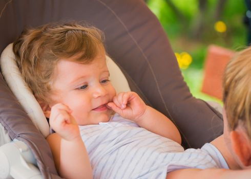 Mother with her baby playing together outdoor at garden.