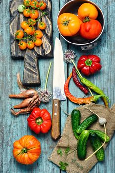 Tomato,pepper and cucumbers from the summer harvest on wooden background