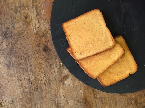 3 slices of toasted bread on an old table