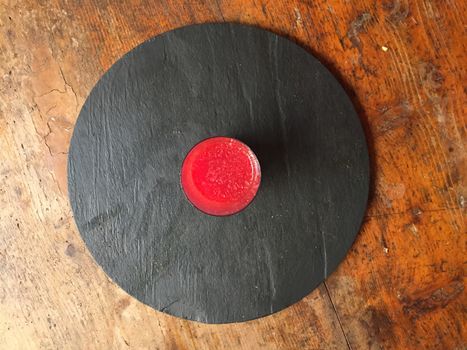 healthy drink, red orange juice on a circular black stone dish