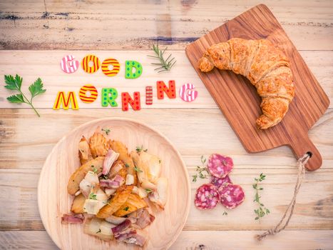 Breakfast  setup on wooden table with colourful Good Morning words.