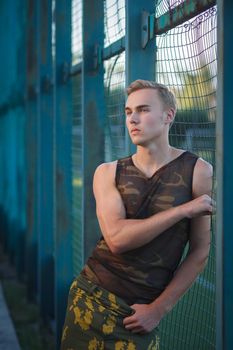 Muscular man in military pants outdoor fashion shoot