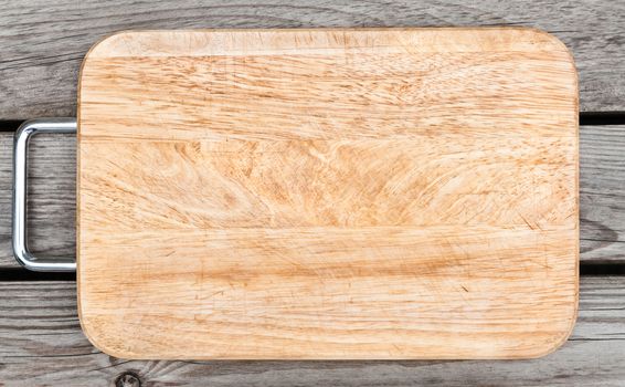 Top view of wooden cutting board on old wooden table