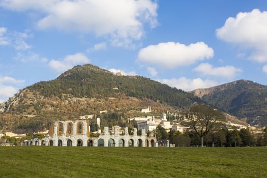 Panoramic view of a Roman amphitheater located next to an Umbrian medieval town