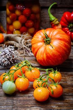 Harvest of summer yellow tomatoes on wooden background