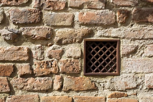 View of a detail of an ancient wall with grate