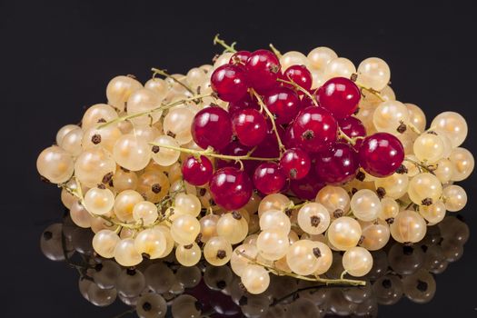 Heap of white currant and redcurrant isolated on black background.
