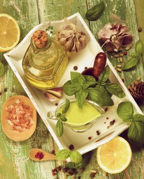 Retro Styled Ingredients and Freshly Made Creamy Pesto Sauce in Glass Gravy Boat in White Wooden Tray. Top View on Cracked Wooden background