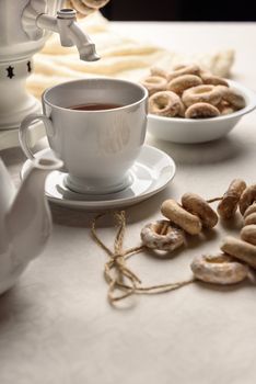 a samovar with bagels and hot tea on the white tablecloth