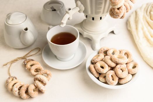 a samovar with bagels and hot tea on the white tablecloth