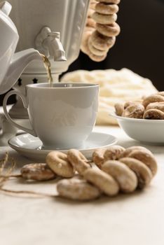 a samovar with bagels and hot tea on the white tablecloth