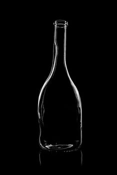 transparent bottle of brandy on a black background with reflection