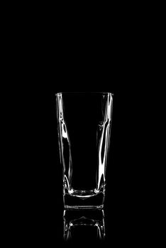 transparent glass for brandy or cognac on black background with reflection