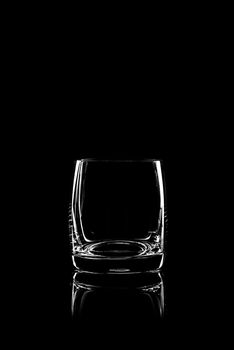 transparent glass for brandy or cognac on black background with reflection