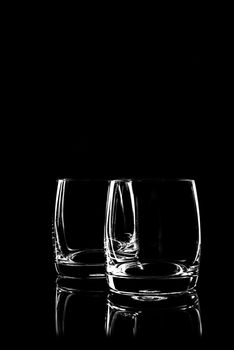 transparent glass for brandy or cognac on black background with reflection