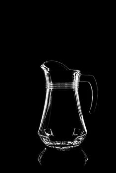 transparent glass for juice on black background with reflection