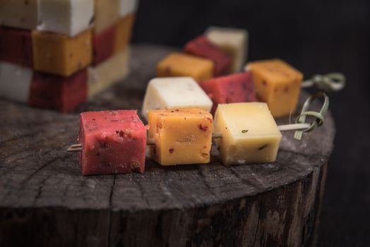 many kinds of cheeses on wooden end of a tree