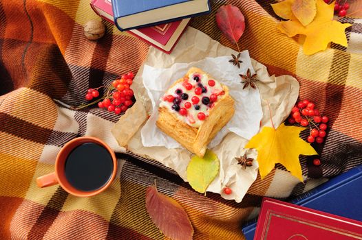 Romantic autumn still life with books, plaid, cake, coffee cup and leaves, top view