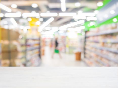 White wooden board empty table in front of blurred background. Perspective white wood over blur in supermarket - can be used for display or montage your products. Mock up for display of product.