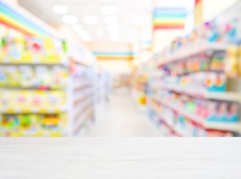 White wooden board empty table in front of blurred background. Perspective white wood over blur in kids toys store - can be used for display or montage your products. Mockup for display of product.