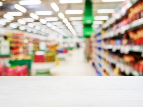 White wooden board empty table in front of blurred background. Perspective white wood over blur in supermarket - can be used for display or montage your products. Mockup for display of product.