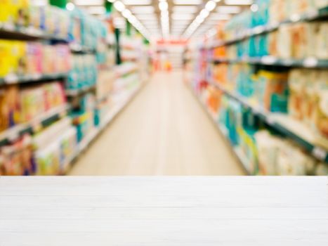 White wooden board empty table in front of blurred background. Perspective white wood over blur in supermarket - can be used for display or montage your products. Mockup for display of product.