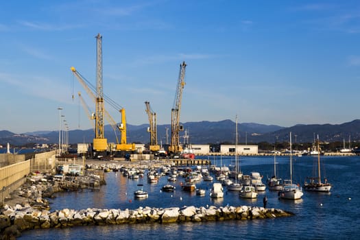 Panoramic view of a commercial port in a sunny morning with mountains in the background