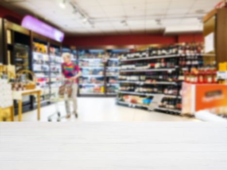 White wooden board empty table in front of blurred background. Perspective white wood over blur in supermarket - can be used for display or montage your products. Mockup for display of product.