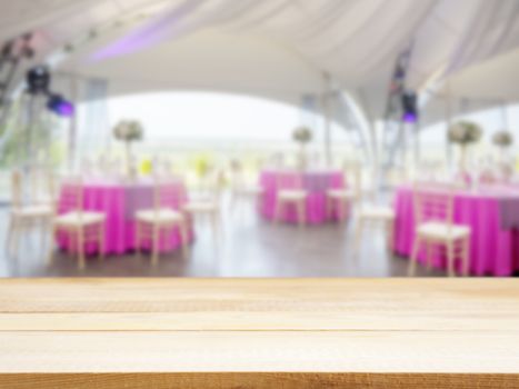 Light wooden empty table in front of blurred restaurant interior background. Perspective light wood board over blur in restaurant or cafe - mockup for display or montage your products